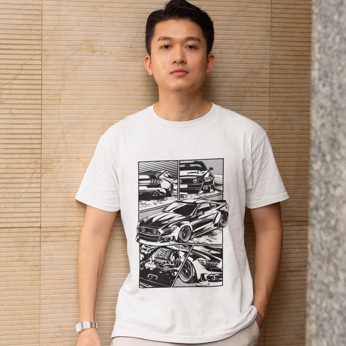 Person wearing a white t-shirt with black graphic design against a beige wall.