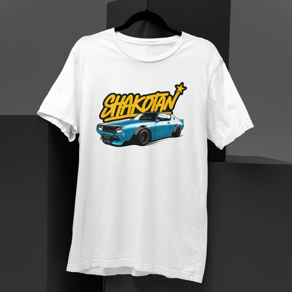 White t-shirt with a graphic design of a car and 'Shakotan' text on a black background