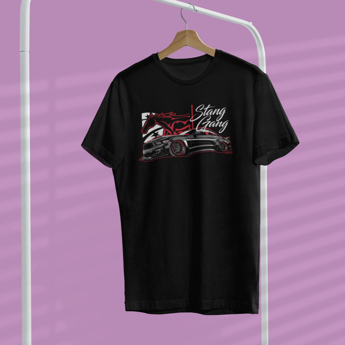 Black t-shirt with graphic design on a hanger against a purple background