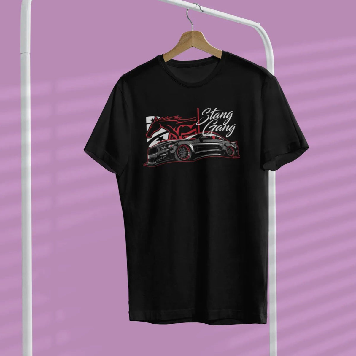 Black t-shirt with graphic design on a hanger against a purple background