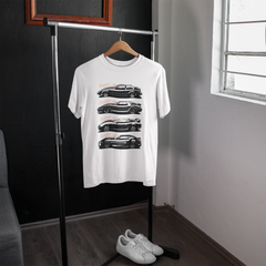 White t-shirt with black car graphics on a hanger in a room with a window.