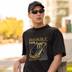 Man wearing a black t-shirt with a gold car graphic and 'BEAST' text, standing outdoors.