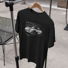 Black t-shirt with car graphic and text on a hanger against a neutral background