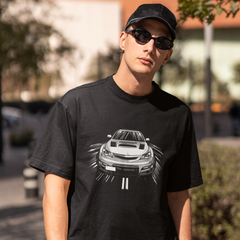 Person wearing a black t-shirt with a car graphic outdoors