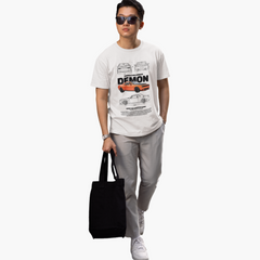 Person wearing a white t-shirt with car graphics and holding a black tote bag on a white background