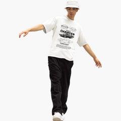 Person wearing a white t-shirt with graphic design and black pants on a white background