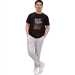 Person wearing a black t-shirt with graphic design and light gray pants on a white background