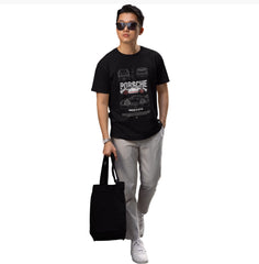 Person wearing a black t-shirt with Porsche design, holding a black bag on a white background