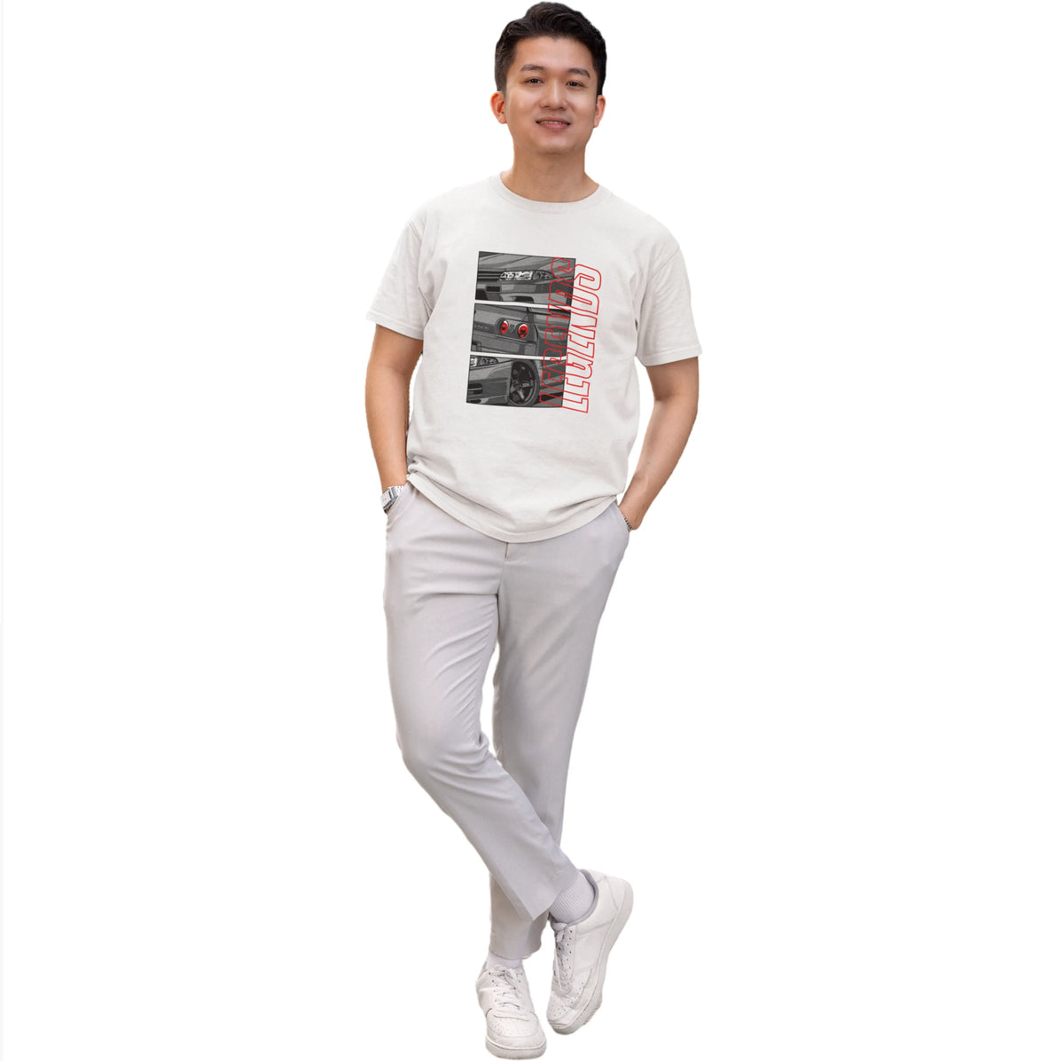 Person wearing a white t-shirt with graphic design and light gray pants on a white background
