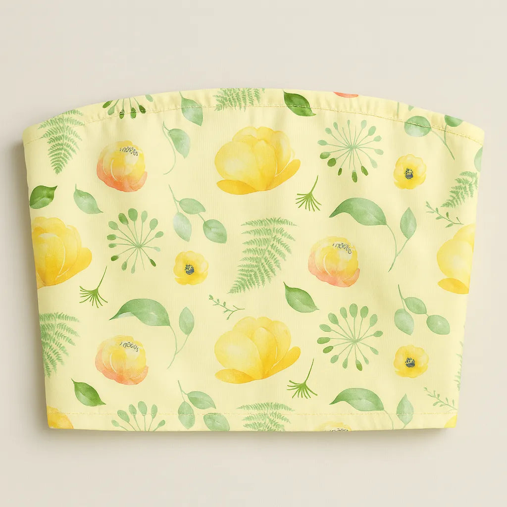 Floral patterned tube top with yellow flowers and green leaves on a light yellow background