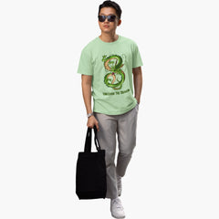 Person wearing a light green t-shirt with a graphic design, holding a black tote bag on a white background