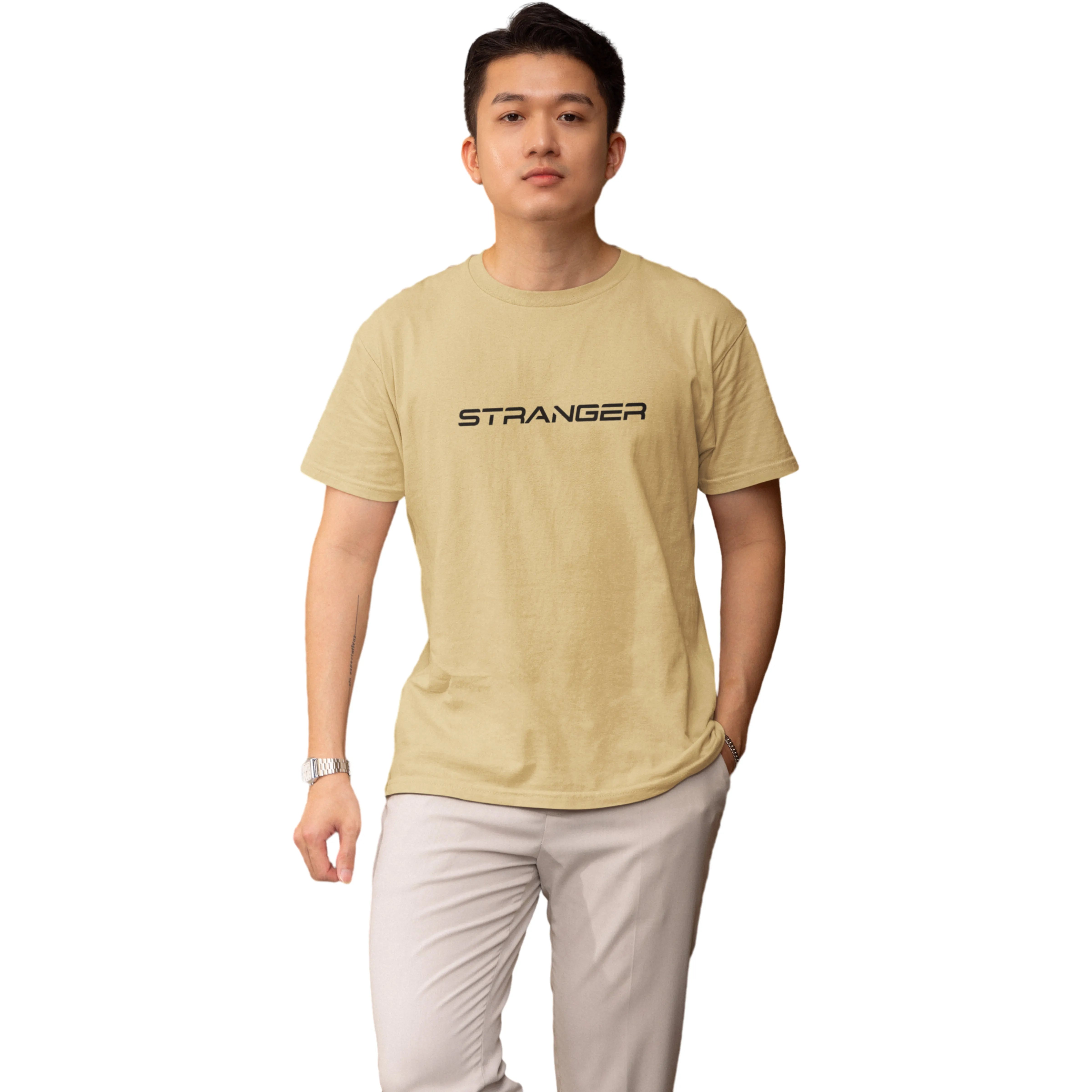 Person wearing a beige t-shirt with 'STRANGER' printed on it against a white background