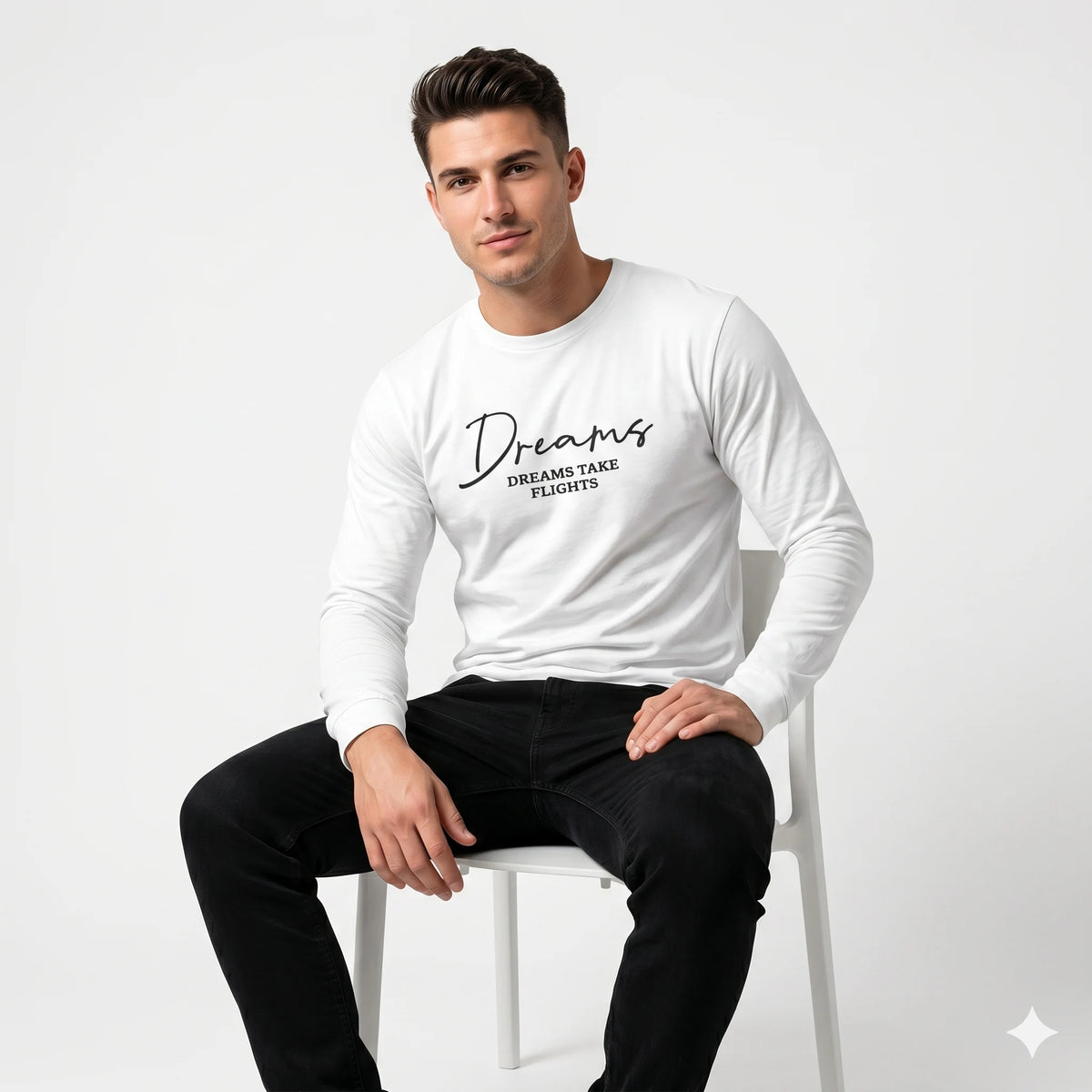 Man wearing a white long-sleeve shirt with text sitting on a white chair against a light gray background