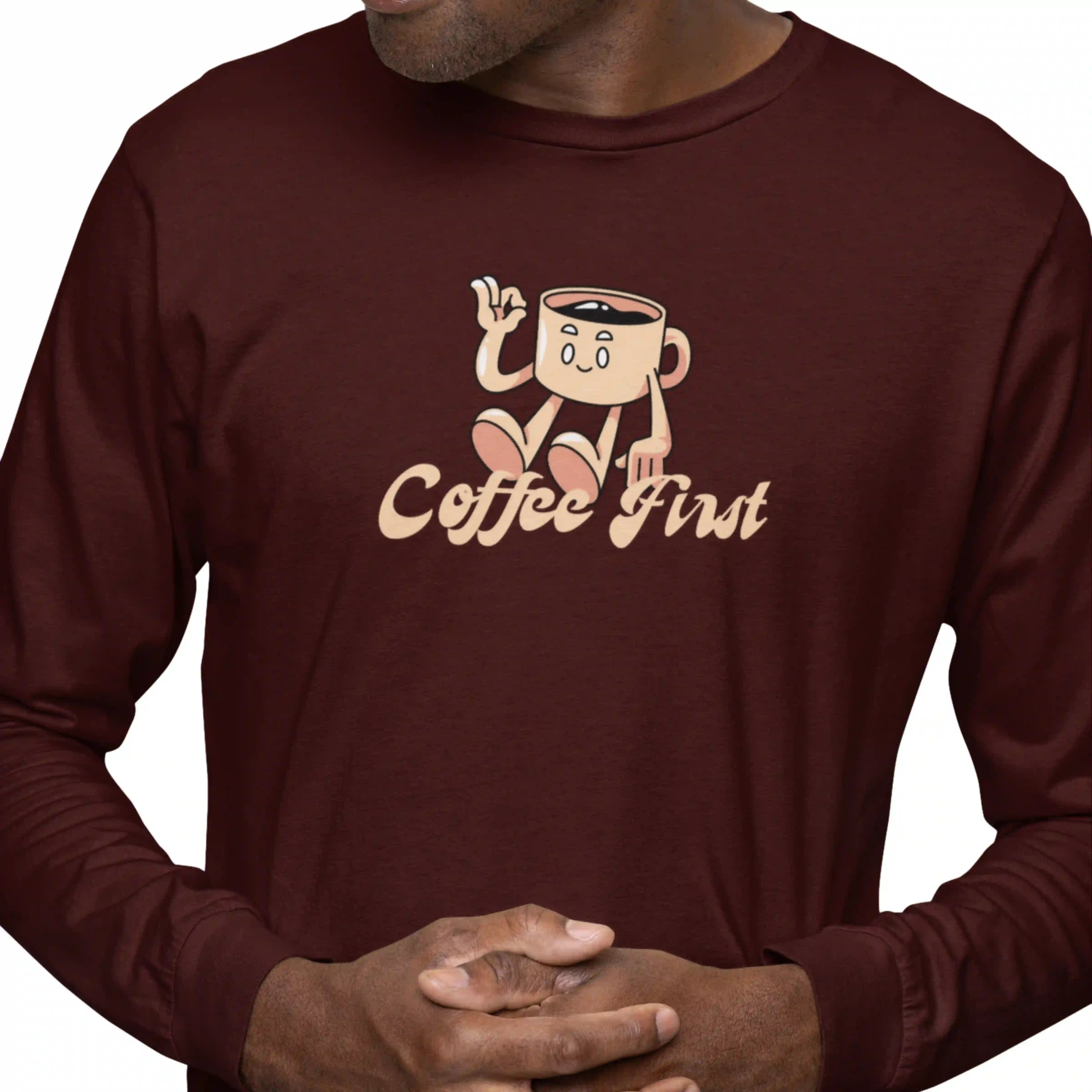 Person wearing a maroon long-sleeve shirt with a cartoon coffee cup design and 'Coffee First' text.