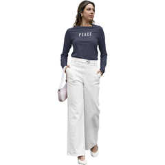 Woman wearing a navy blue 'PEACE' shirt and white pants on a white background