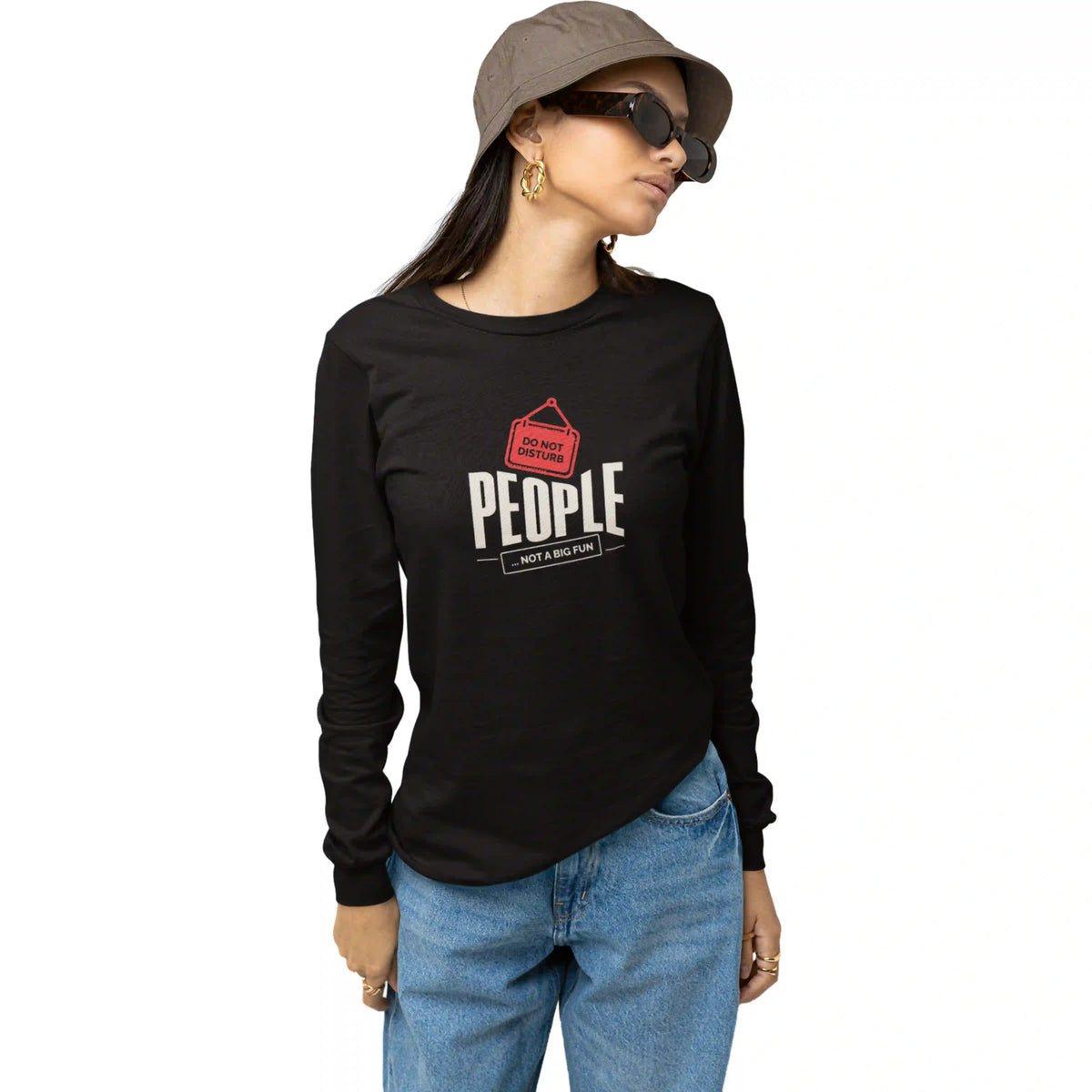 Person wearing a black long-sleeve shirt with a graphic and text, blue jeans, and a hat on a white background