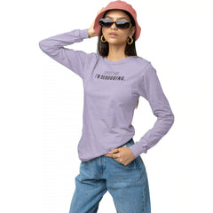 Person wearing a purple long-sleeve shirt with text, blue jeans, and a pink hat on a white background
