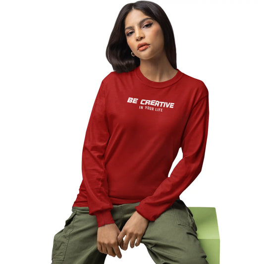 Person wearing a red sweatshirt with 'Be Creative In Your Life' text, sitting on a green bench.