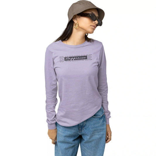Woman wearing a purple long-sleeve shirt with text, blue jeans, and a brown hat on a white background