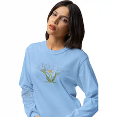 Woman wearing a light blue sweatshirt with a floral design on a white background