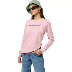 Person wearing a pink long-sleeve shirt with 'CALM DOWN' text, blue jeans, and a green bucket hat on a white background.