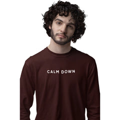 Man wearing a brown sweatshirt with 'CALM DOWN' text on a white background