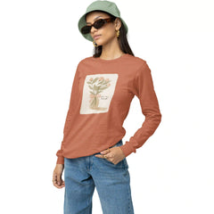 Woman wearing a brown long-sleeve shirt with a floral design, blue jeans, and a green bucket hat on a white background.
