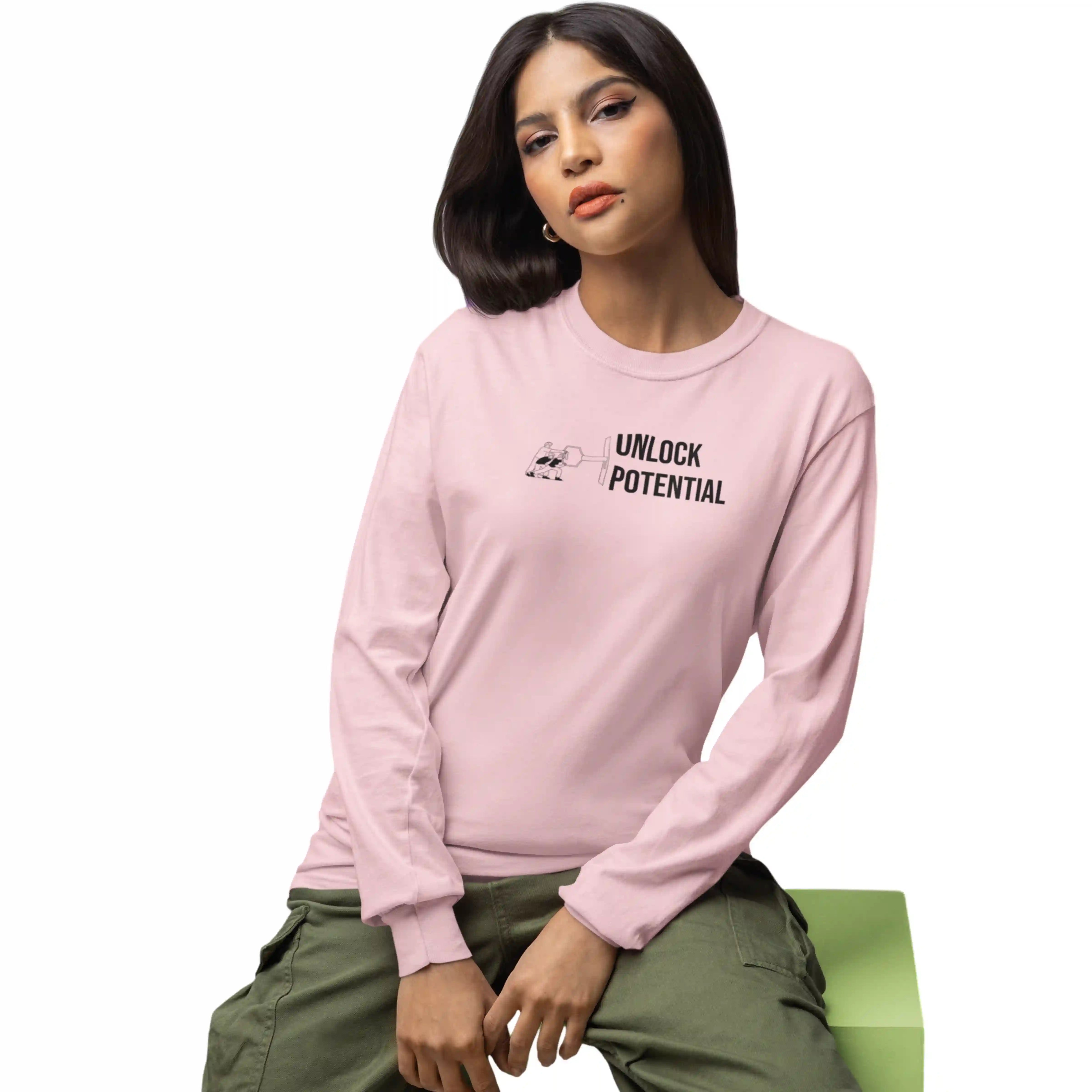 Person wearing a pink long-sleeve shirt with text, sitting on a green chair against a white background