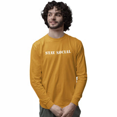Man wearing a mustard yellow long-sleeve shirt with 'STAY SOCIAL' text on a white background