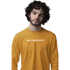 Man wearing a mustard yellow long-sleeve shirt with 'SHUT YOUR MOUTH' text on a white background