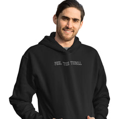 Man wearing a black hoodie with 'FEEL THE THRILL' text on a white background