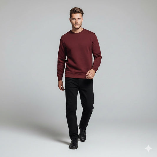 Man wearing a burgundy sweater and black pants on a gray background